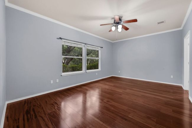 The private primary suite boasts tall ceilings, a ceiling fan, and a luxurious en-suite bathroom complete with a double vanity, garden soaking tub, separate shower, and a large walk-in closet. | Image 15
