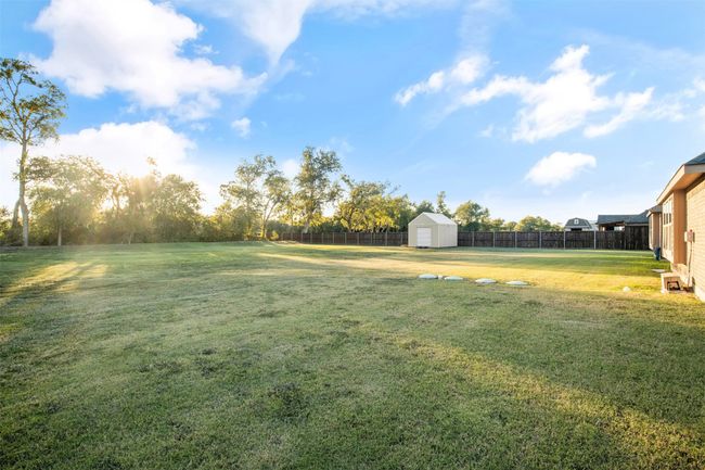 View of yard featuring an outbuilding, a storage unit, and a fenced backyard | Image 31