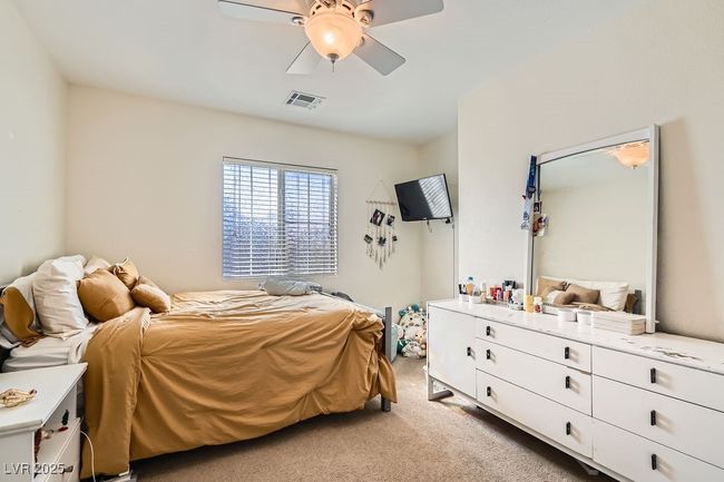 Bedroom featuring ceiling fan, visible vents, and light colored carpet | Image 21