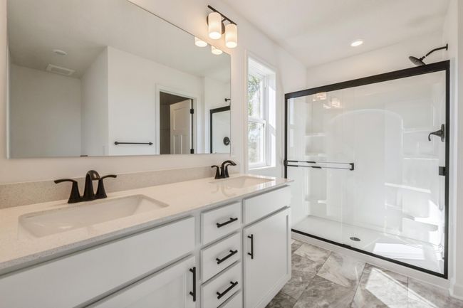 (*Photo of actual home) The spacious primary ensuite bathroom has a large double vanity | Image 11