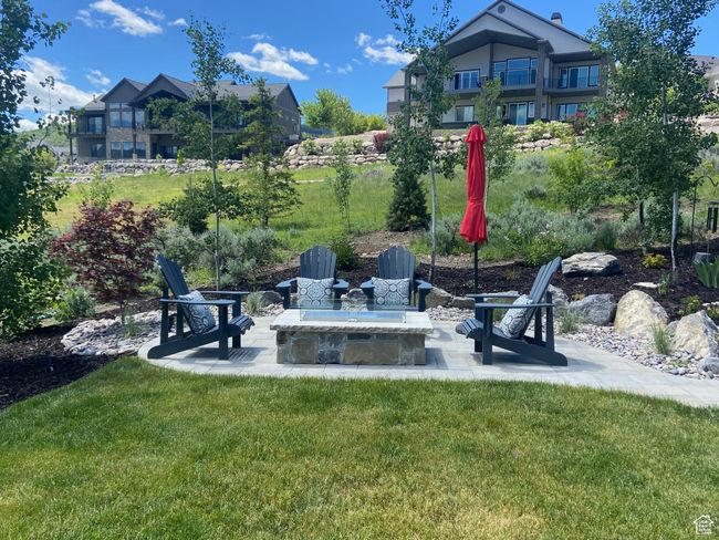 View of green lawn featuring a patio and an outdoor fire pit | Image 73