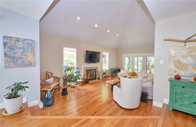 Living room featuring a wealth of natural light, high vaulted ceiling, and wood-type flooring | Image 14