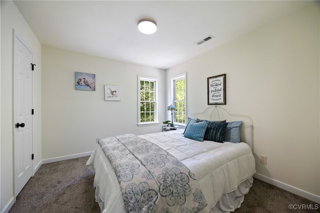 Bedroom with dark carpet, visible vents, and baseboards | Image 29
