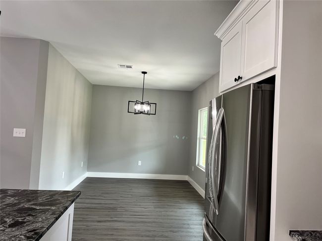 Unfurnished dining area featuring dark wood-style floors and a chandelier | Image 4