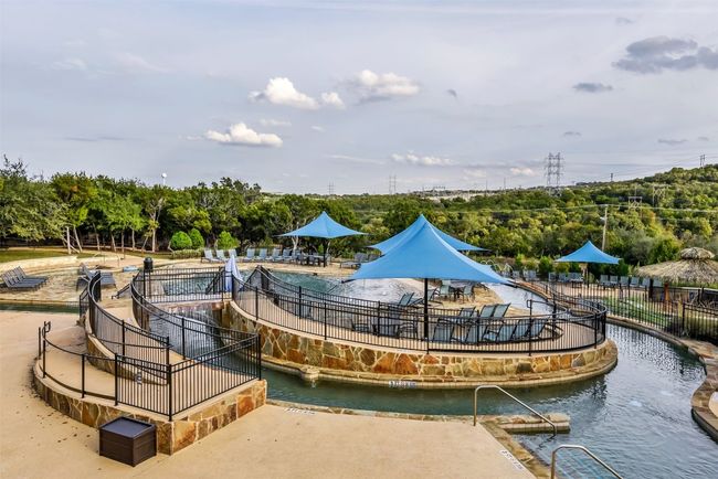 View of home's community featuring view of wooded area, a pool, and a water view | Image 24