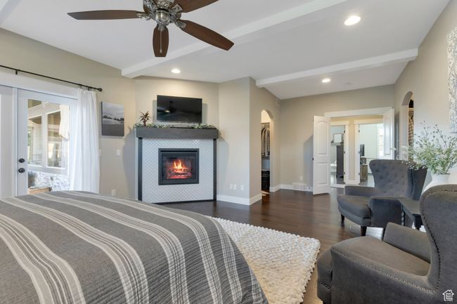 Bedroom with arched walkways, wood finished floors, beamed ceiling, and baseboards | Image 22