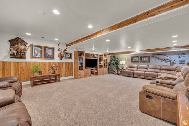 Living room with carpet floors, wood walls, recessed lighting, a wainscoted wall, and beam ceiling | Image 20
