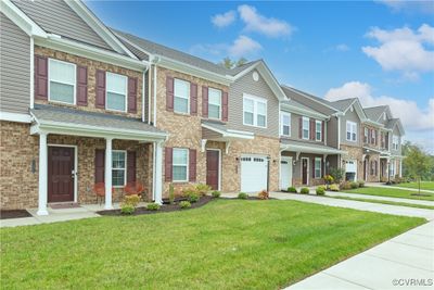 Townhome / multi-family property featuring a garage and a front lawn | Image 3