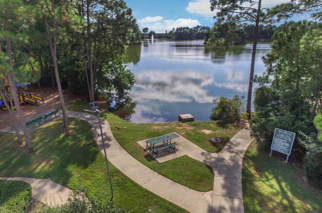 One of the nearby fishing areas serene lakeside setting with a walking path, lush greenery, and a nearby playground, perfect for family outings and relaxation. | Image 34