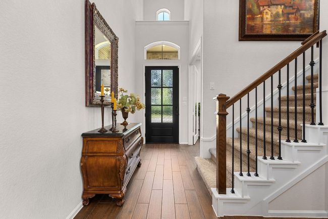 Entryway with healthy amount of natural light, dark wood-style flooring, and stairway | Image 5