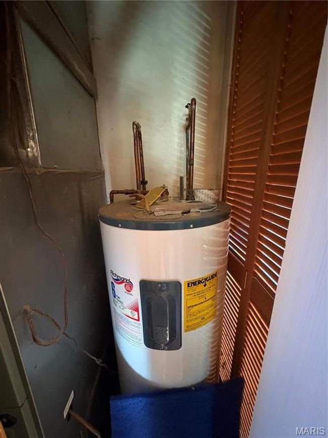 Utility room featuring electric water heater | Image 23