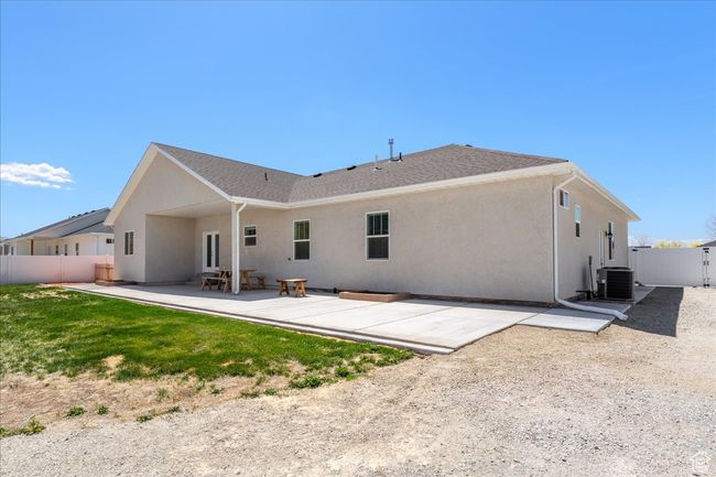 Rear view of house with central AC, fence, a patio, and stucco siding | Image 55