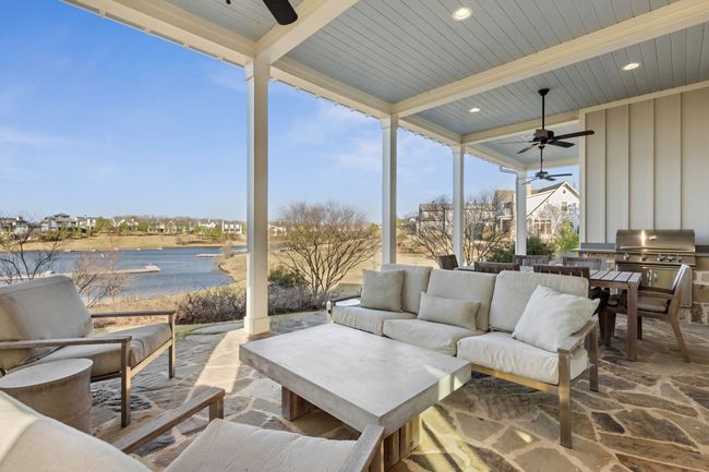 View of patio with a ceiling fan, a water view, and an outdoor living space | Image 14