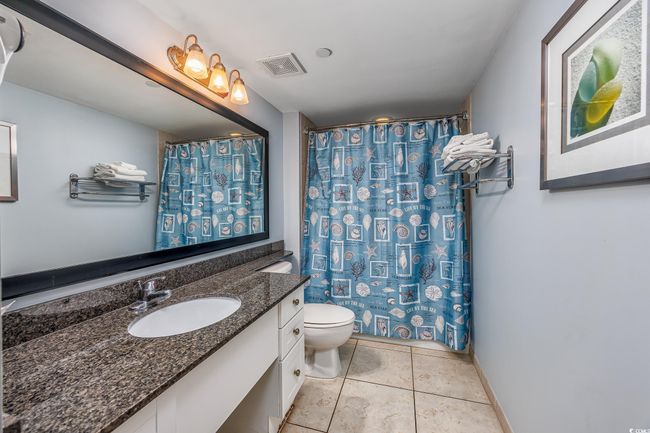 Bathroom featuring tile patterned floors, a shower with shower curtain, toilet, vanity, and visible vents | Image 14