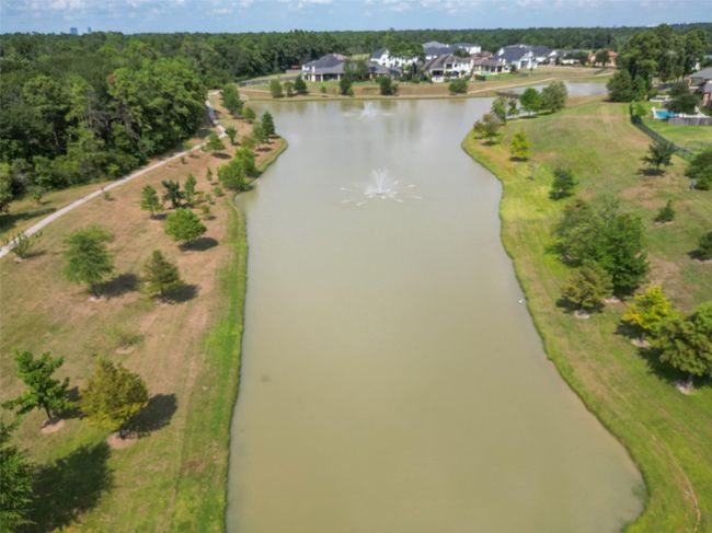 Discover tranquility in this picturesque neighborhood featuring a fishing pond, scenic walking paths, and lush greenery, perfect for relaxation and outdoor activities. | Image 36