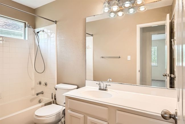 Bathroom with toilet, tub / shower combination, and vanity | Image 18