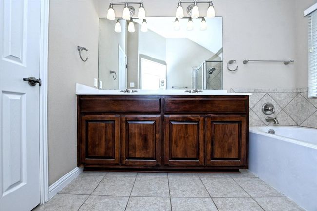 Full bathroom featuring a shower stall, tile patterned floors, double vanity, and a garden tub | Image 20