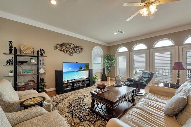 Living area has beautiful wood floors and plantation shutters which are featured throughout the home. It also opens to the deck overlooking Jones Bay. | Image 4