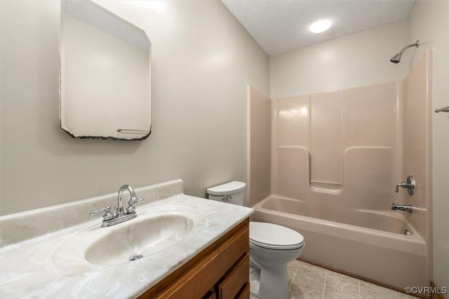 Full bathroom with a textured ceiling, vanity, tile patterned flooring, toilet, and tub / shower combination | Image 43