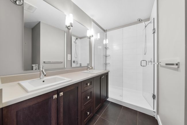 Bathroom featuring a shower stall, tile patterned flooring, and double vanity | Image 32