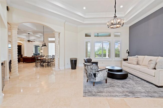 Framed by elegant columns and filled with natural light, this versatile living space offers timeless architectural detail and effortless flow. | Image 14