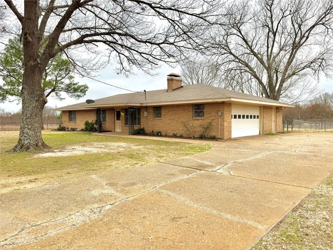 Ranch-style house with a garage and a front yard | Image 6