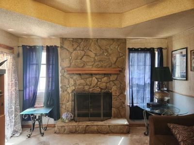 Unfurnished living room with concrete flooring, a fireplace, and a textured ceiling | Image 3