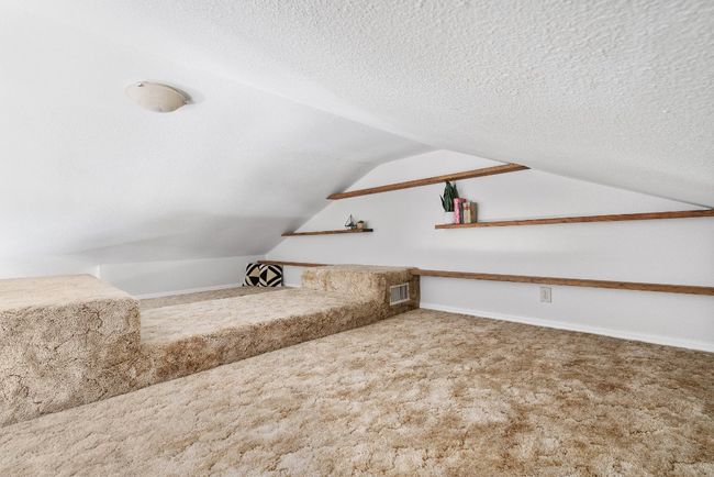 Additional living space with visible vents, a textured ceiling, carpet floors, baseboards, and vaulted ceiling | Image 21
