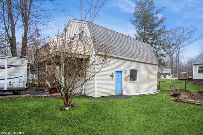Rear view of property with a shingled roof, fence, a gambrel roof, and a yard | Image 19