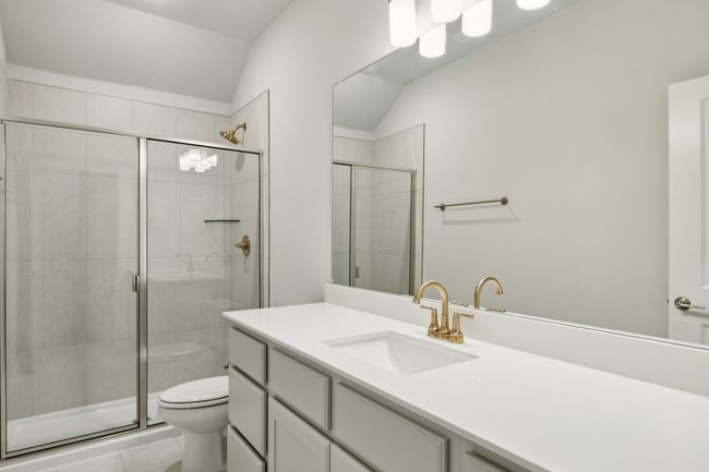 Full bathroom featuring vanity, a shower stall, and lofted ceiling | Image 27
