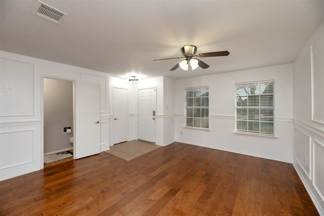 Living room, a decorative wall, ceiling fan, and hardwood /engineered wood flooring | Image 6