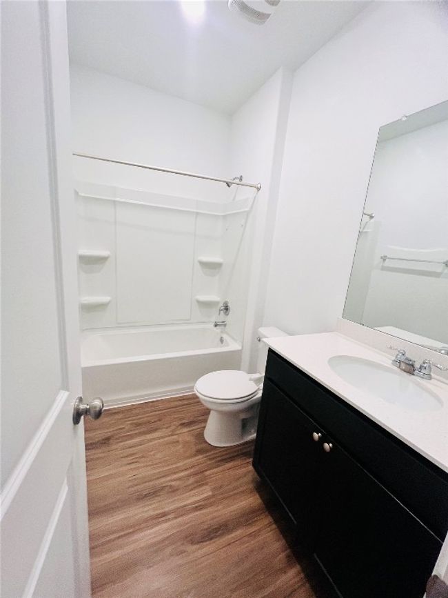Full bath with vanity, wood finished floors, and shower / washtub combination | Image 15