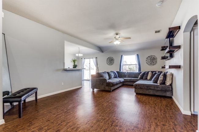 Living room with ceiling fan with notable chandelier and dark hardwood / wood-style flooring | Image 4