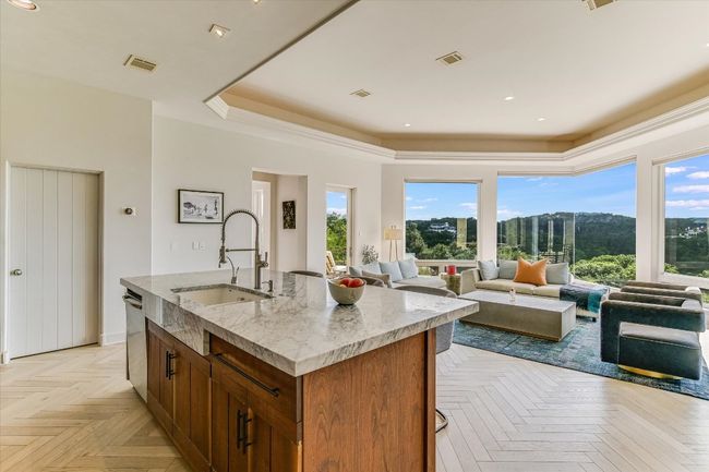 Kitchen featuring plenty of natural light, a center island with sink, dishwasher, light stone counters, and recessed lighting | Image 11