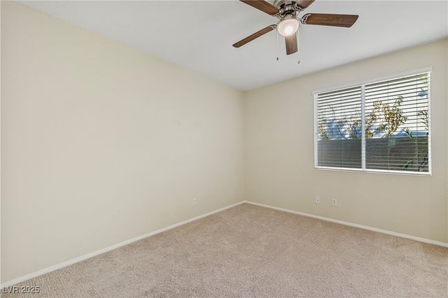 Carpeted empty room featuring baseboards and a ceiling fan | Image 16