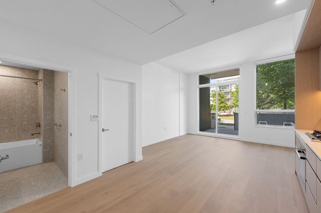 Unfurnished living room with light wood-style flooring and attic access | Image 4
