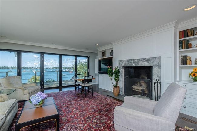 Living room has bi-fold doors that open to the expansive wrap around deck | Image 12