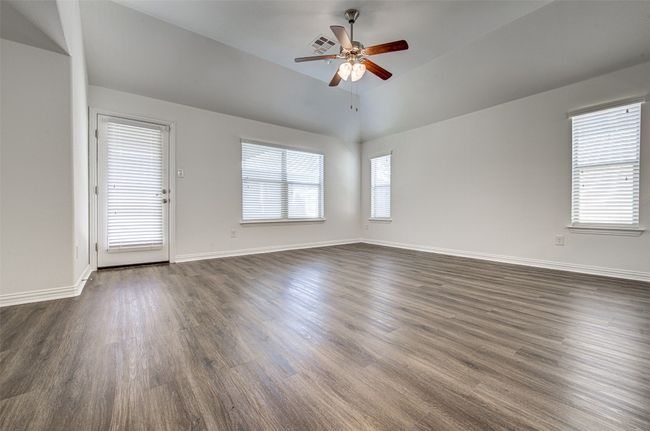 Spare room featuring a ceiling fan, dark wood-style flooring, and vaulted ceiling | Image 20