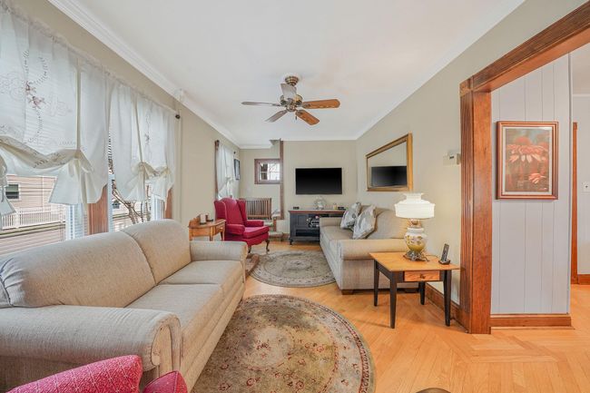 Living area featuring baseboards, ceiling fan, light wood-style flooring, and crown molding | Image 6