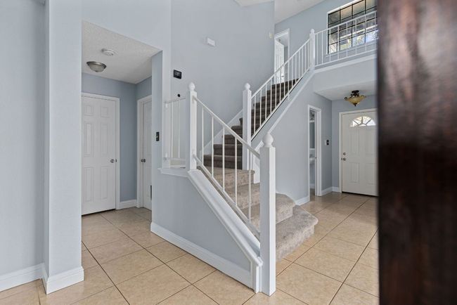 The staircase makes a quiet statement of its own—wide, carpeted steps that rise gently from the heart of the home. | Image 19