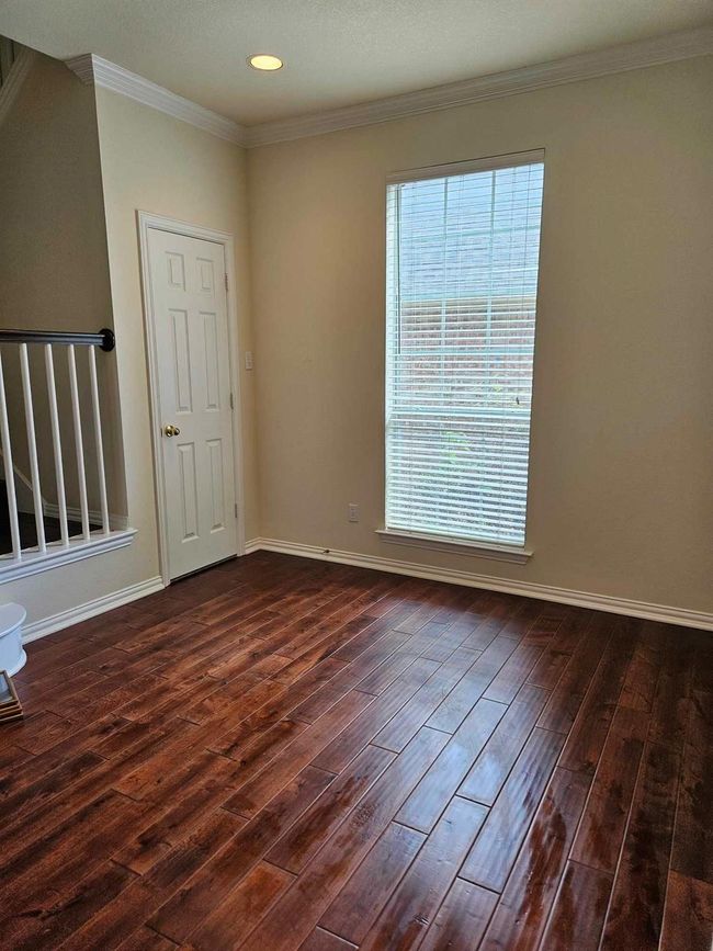 Empty room with dark wood-style floors, ornamental molding, and recessed lighting | Image 17