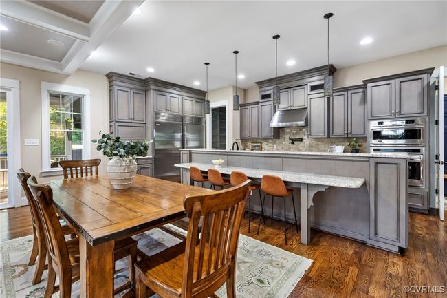 Dining area with dark wood-style floors, beam ceiling, and recessed lighting | Image 8