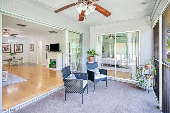 Sunroom with a ceiling fan and a fireplace with raised hearth | Image 13