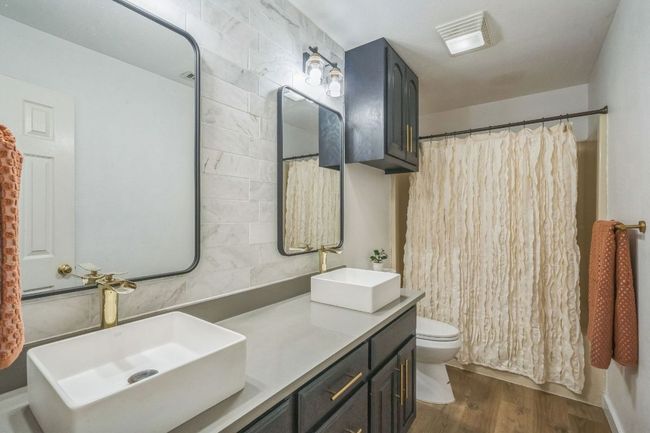 Full bath featuring wood finished floors and double vanity | Image 24