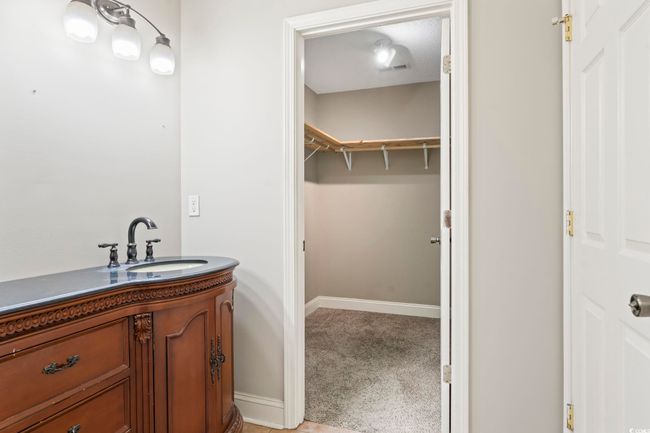 Bathroom with vanity, baseboards, and a spacious closet | Image 22