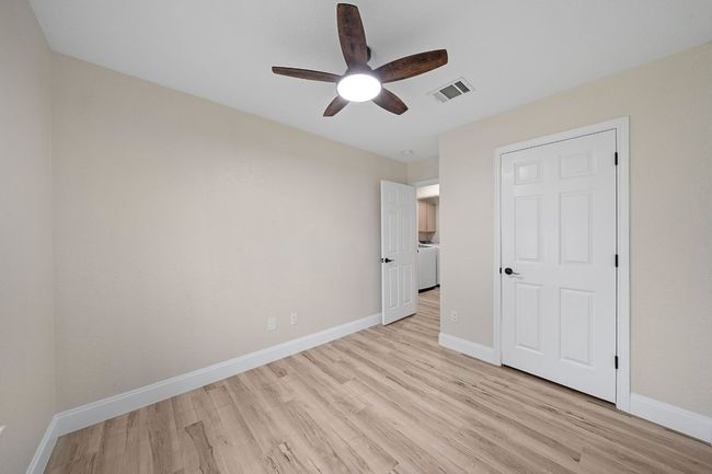 Unfurnished bedroom with light wood finished floors, washer / clothes dryer, and a ceiling fan | Image 25