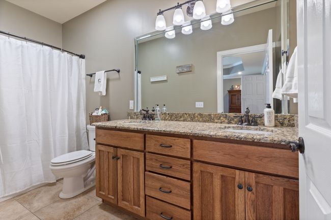 Master Bath has a Tub/Shower Combo with Granite Countertop Custom Double Vanity and Tile Floor | Image 25