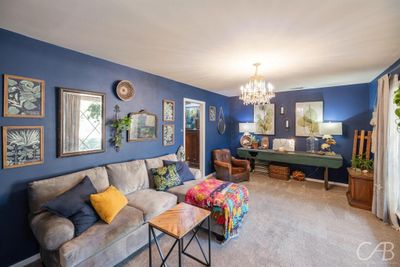 Carpeted living room featuring an inviting chandelier | Image 2