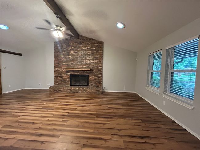 Unfurnished living room with wood finished floors, a ceiling fan, a brick fireplace, and recessed lighting | Image 8