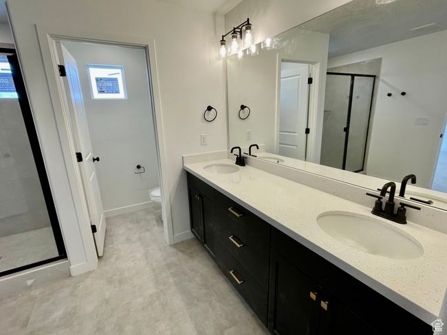 Bathroom featuring a shower stall and double vanity | Image 13